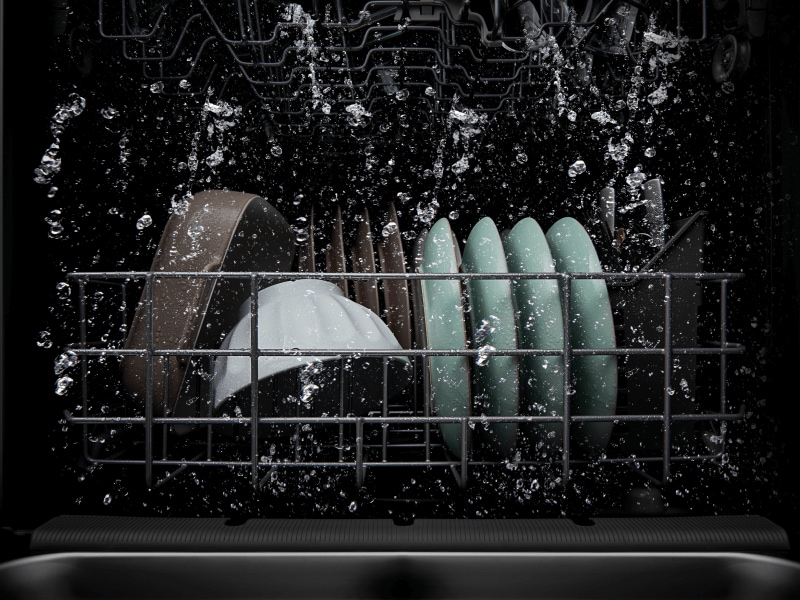 Dishes being cleaned in a dishwasher wash cycle