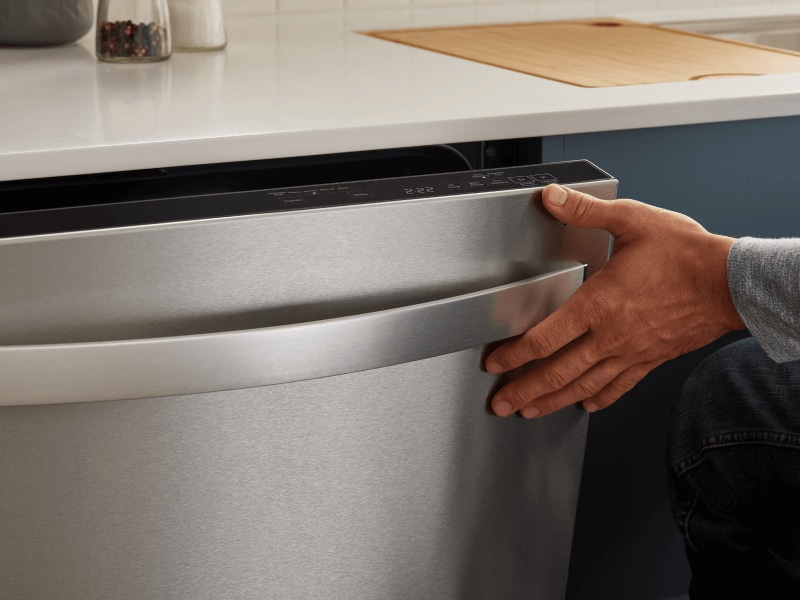 Person closing a top control dishwasher