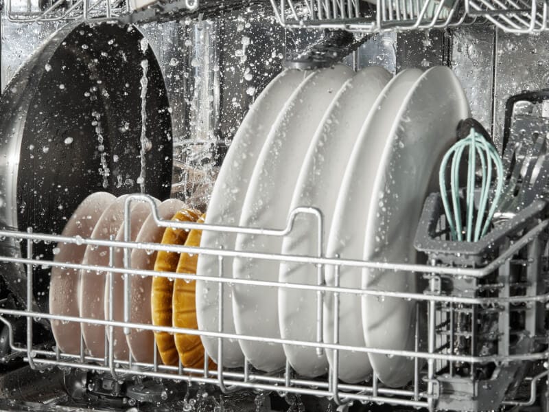 Dishes being rinsed in a dishwasher