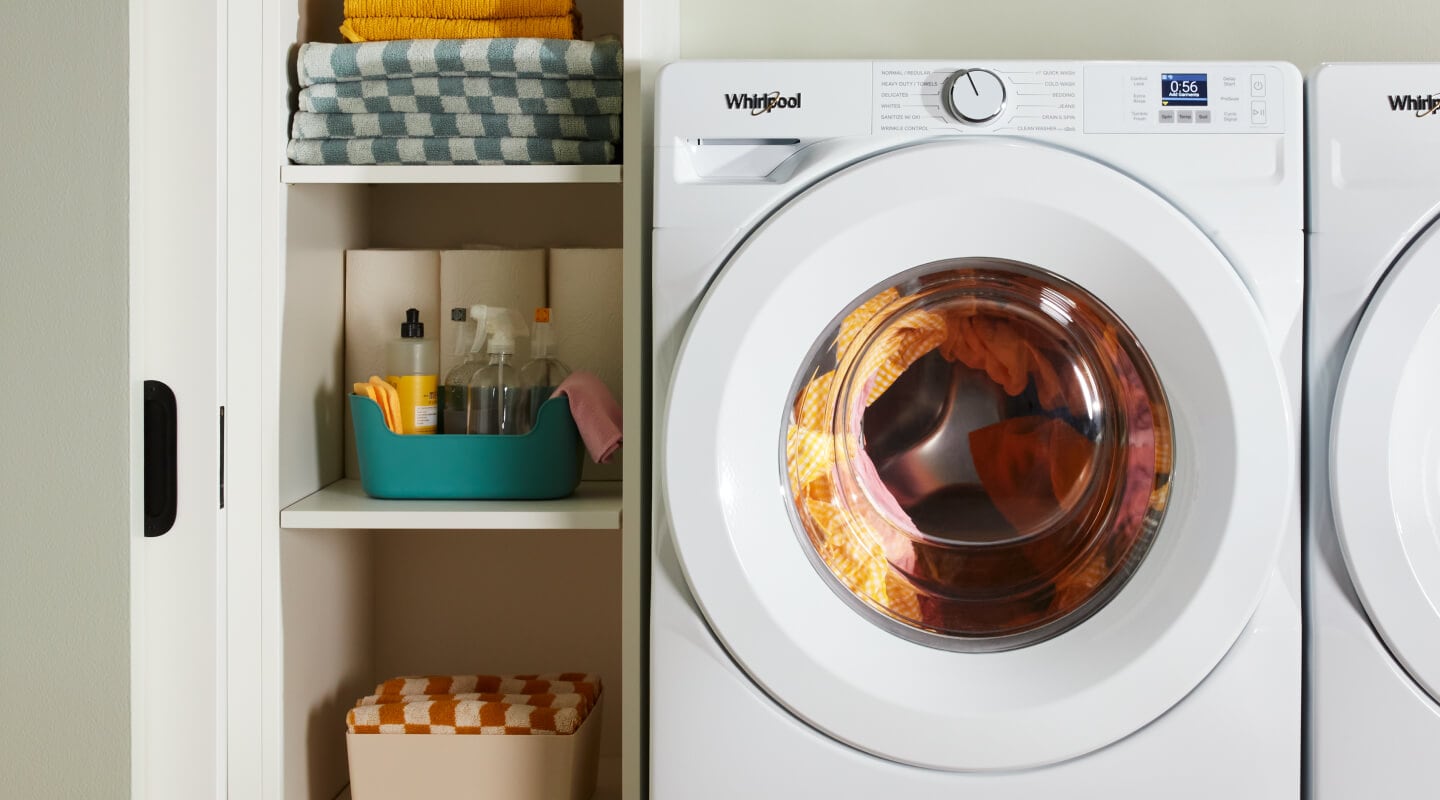 Whirlpool® Washing Machine in a laundry room with vertical shelves to the left of it