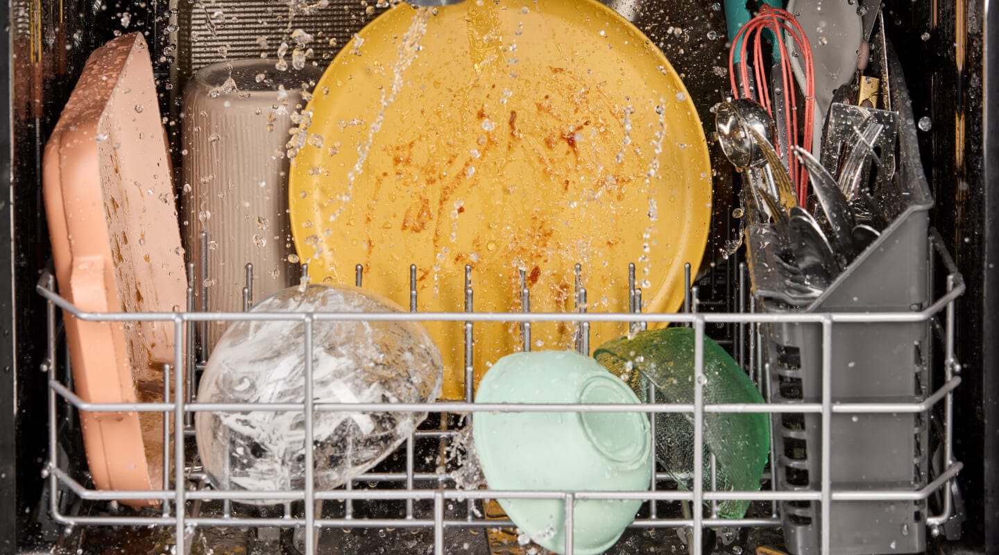 Dirty dishes being washed in a dishwasher Dirty dishes being washed in a dishwasher