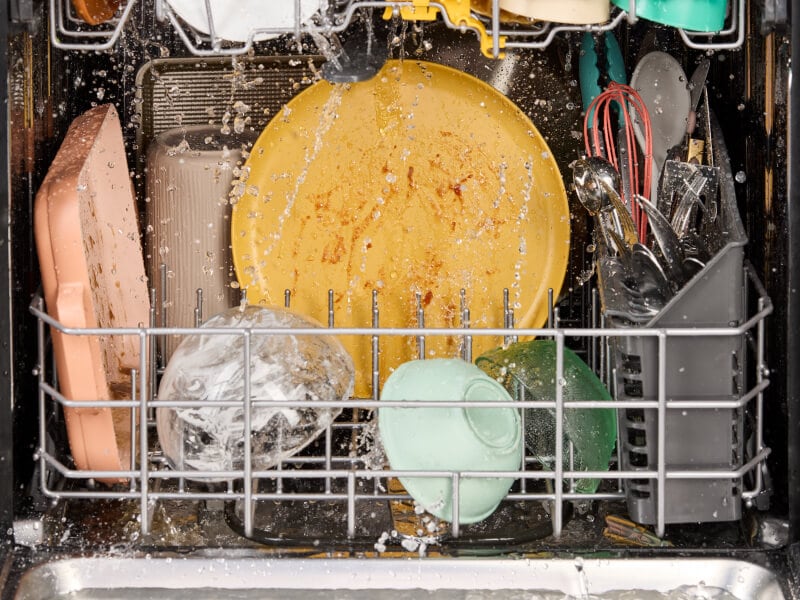 Dirty dishes being washed in a dishwasher Dirty dishes being washed in a dishwasher
