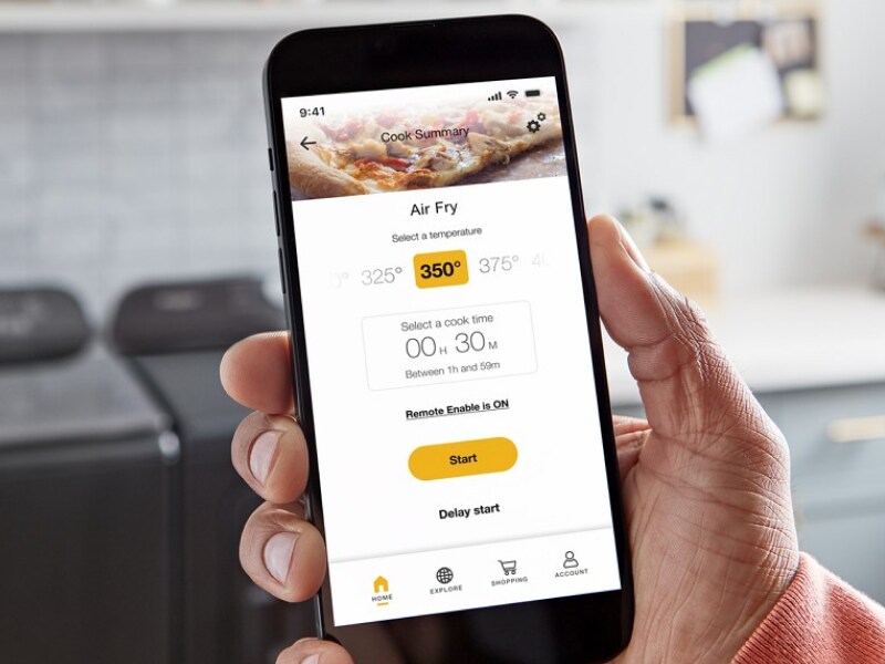 Person using a smartphone to monitor air fry temperatures in their Smart Microwave Oven from Whirlpool brand Person using a smartphone to monitor air fry temperatures in their Smart Microwave Oven from Whirlpool brand
