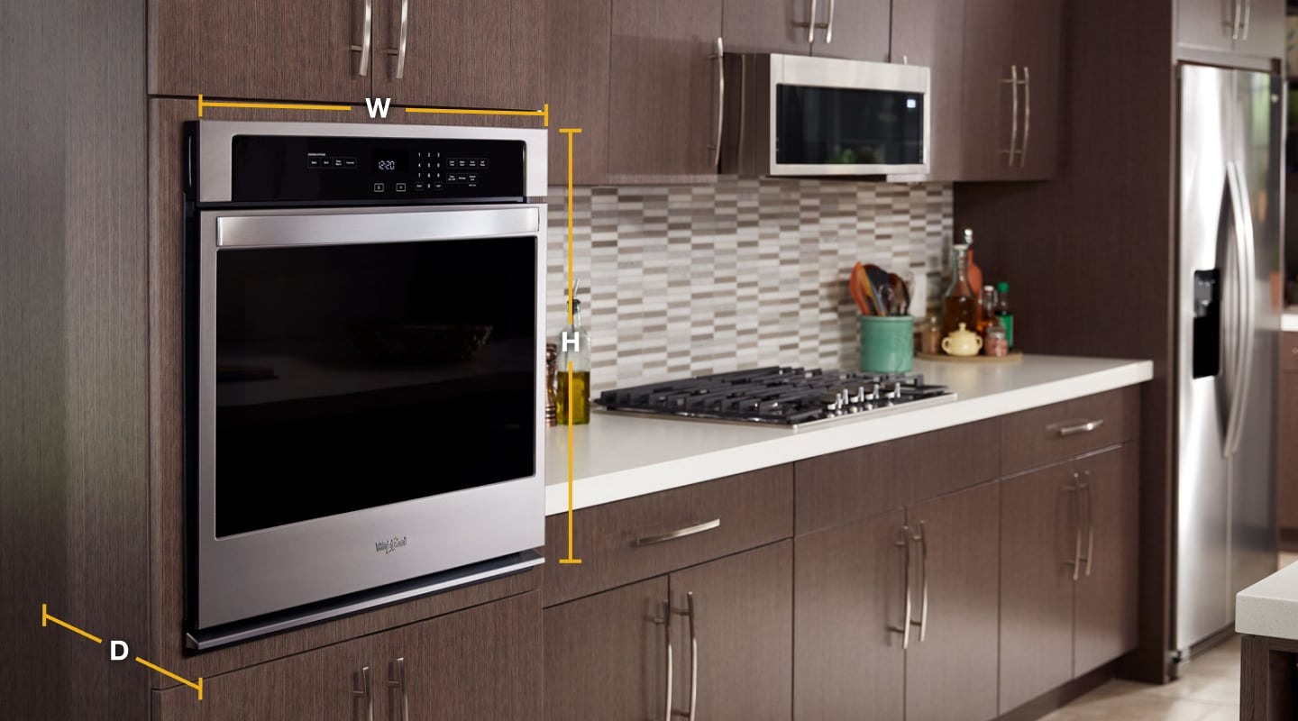 Whirlpool® stainless steel single wall oven set into wood finished cabinets with diagram of width, height and depth. Whirlpool® stainless steel single wall oven set into wood finished cabinets with diagram of width, height and depth.