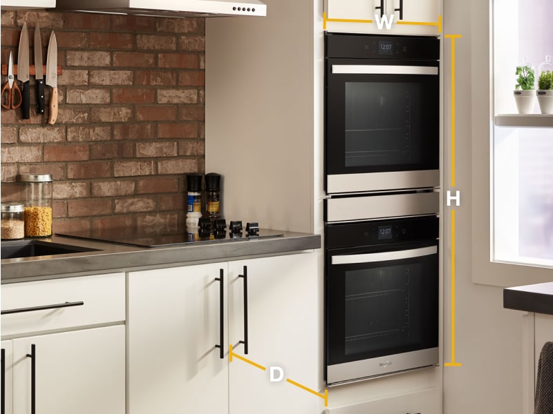 Whirlpool® stainless steel double wall ovens set into white cabinets with diagram of width, height and depth Whirlpool® stainless steel double wall ovens set into white cabinets with diagram of width, height and depth