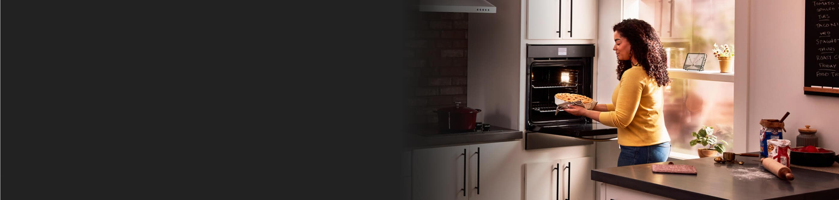 Women placing pie into Whirlpool® wall oven
