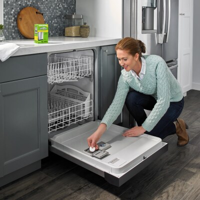 Person putting dishwasher cleaner in dishwasher