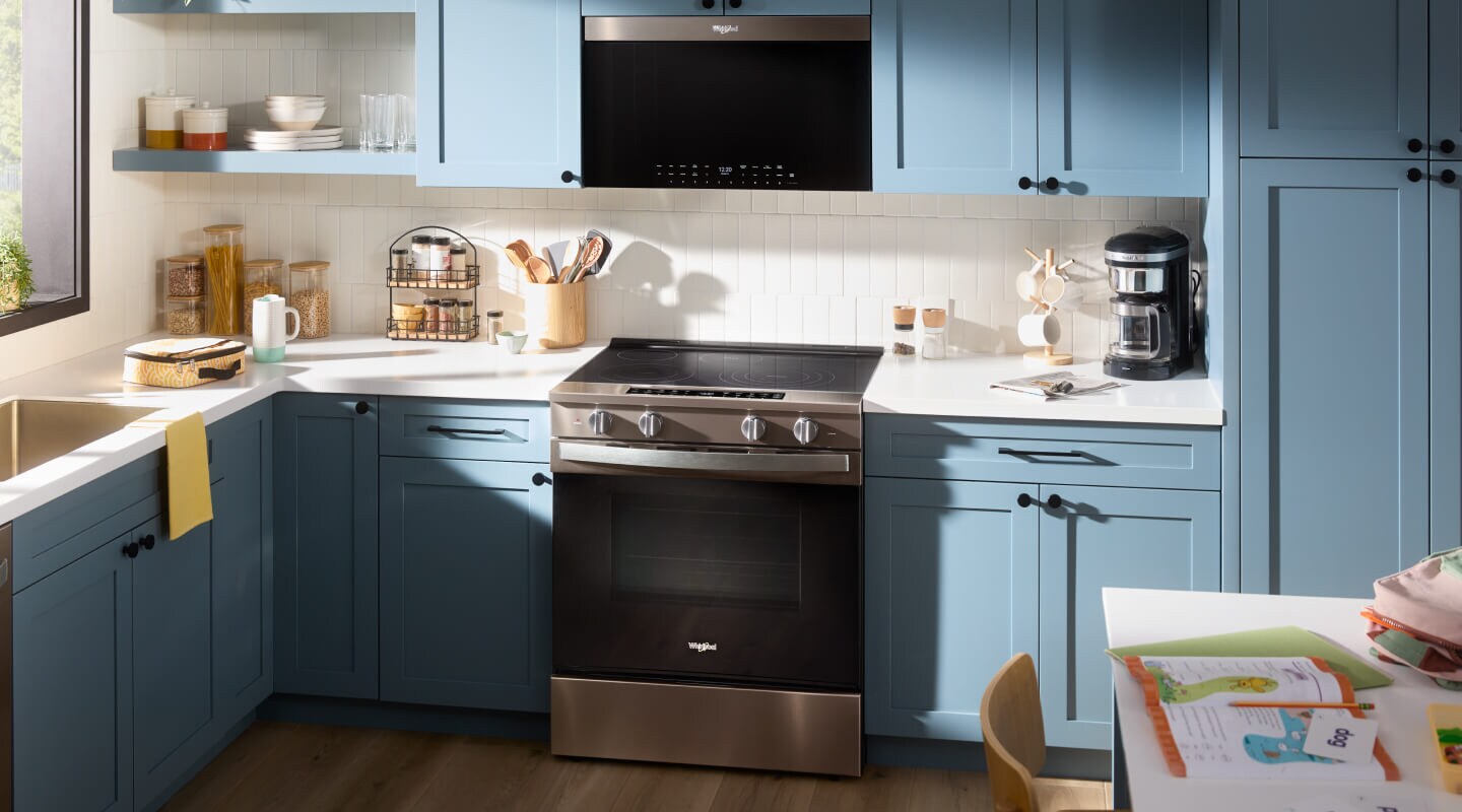 The inside of a kitchen with blue cabinetry