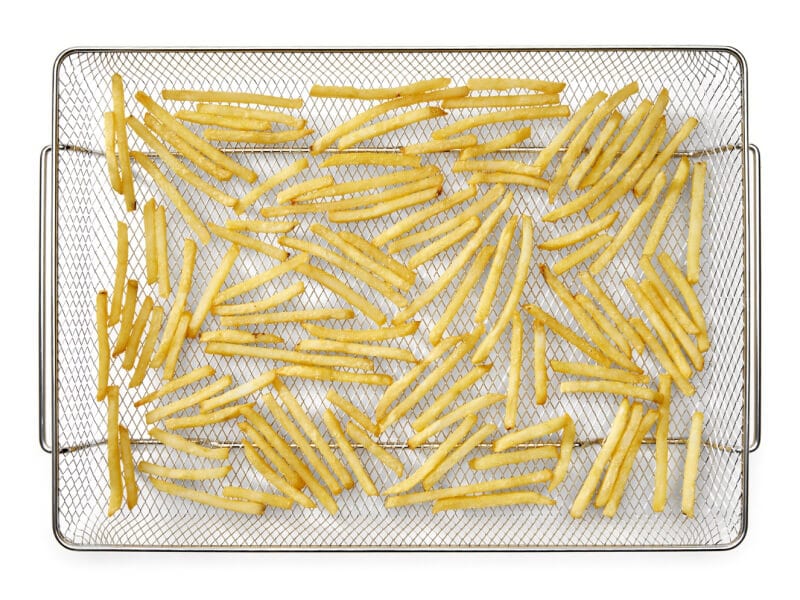 French fries in an air fryer basket French fries in an air fryer basket