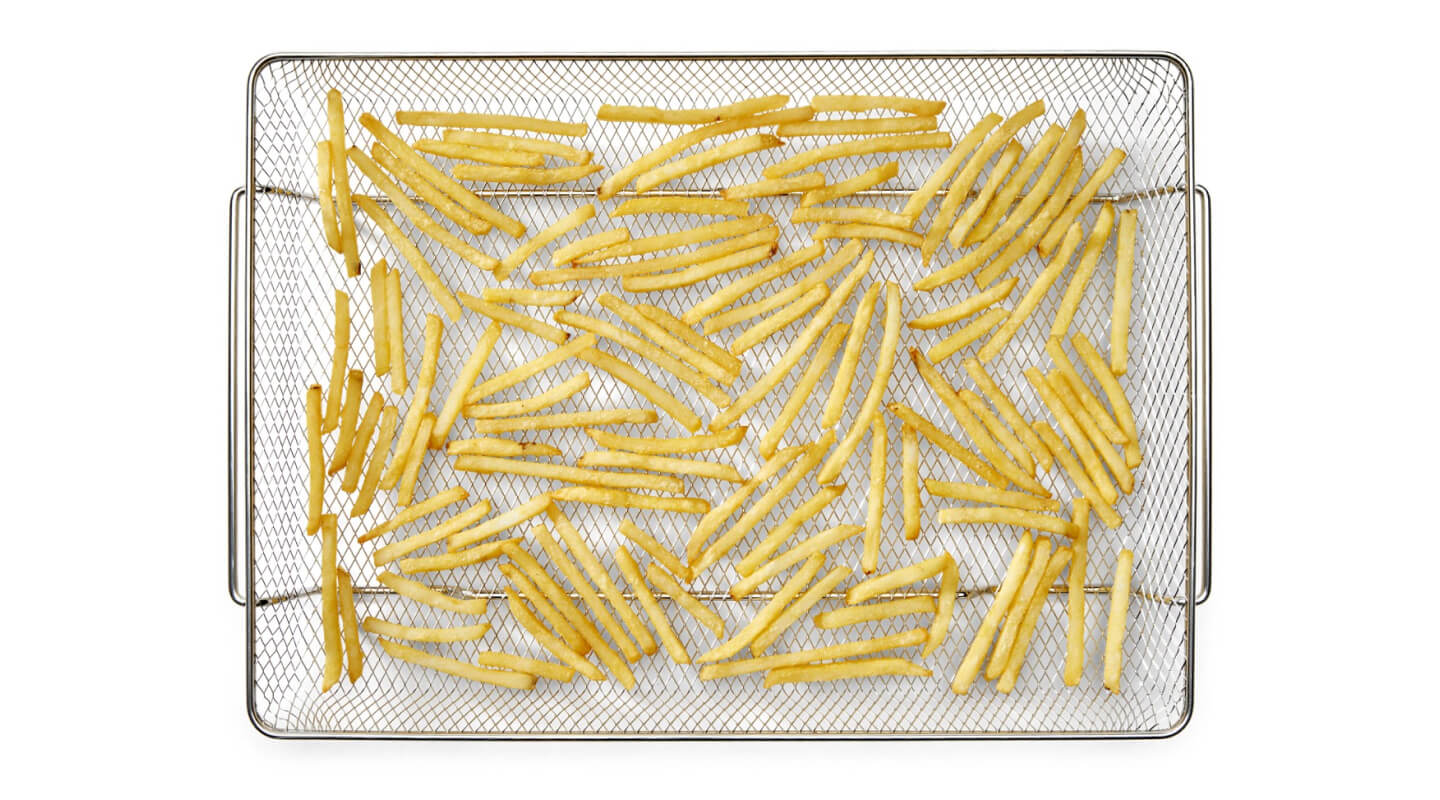 French fries in an air fryer basket French fries in an air fryer basket