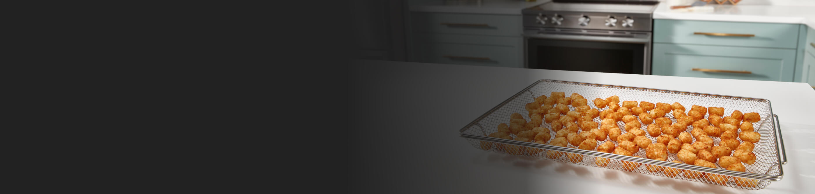 Tater tots in an air fry basket on a kitchen island