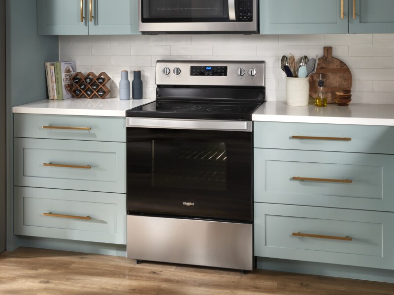 A stainless steel KitchenAid® gas range with pistachio-colored cabinets on either side. A stainless steel KitchenAid® gas range with pistachio-colored cabinets on either side.