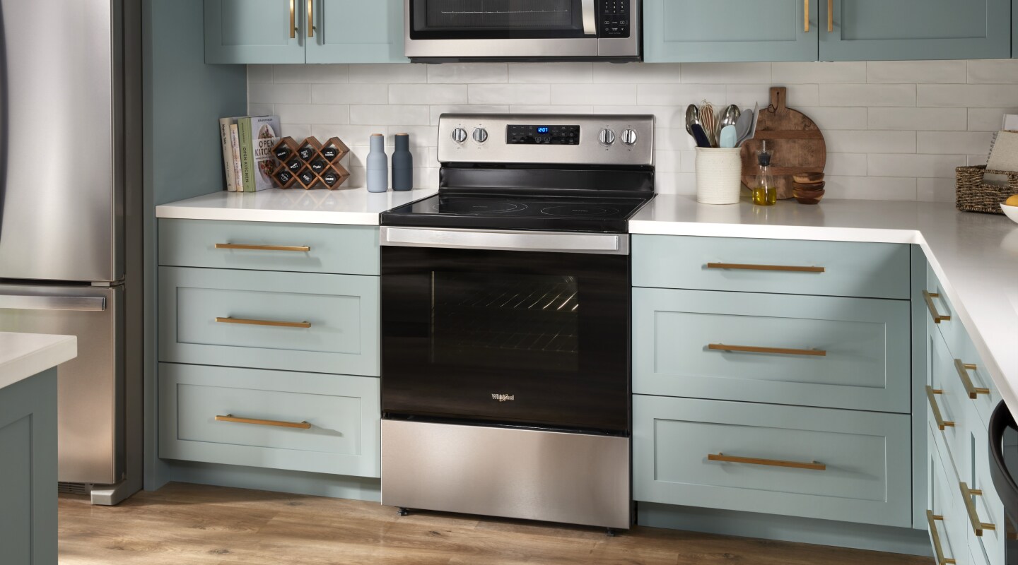 A stainless steel KitchenAid® gas range with pistachio-colored cabinets on either side. A stainless steel KitchenAid® gas range with pistachio-colored cabinets on either side.