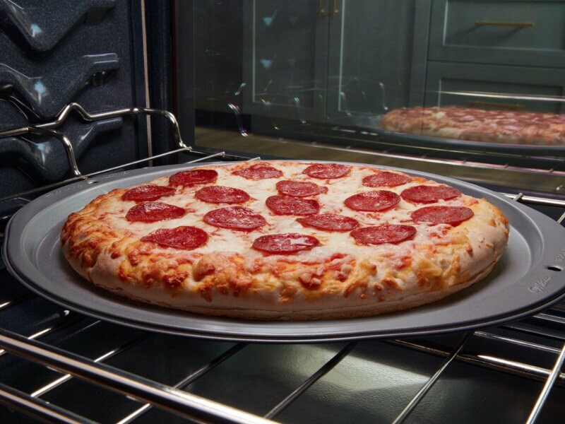 Pepperoni pizza baking in an oven Pepperoni pizza baking in an oven
