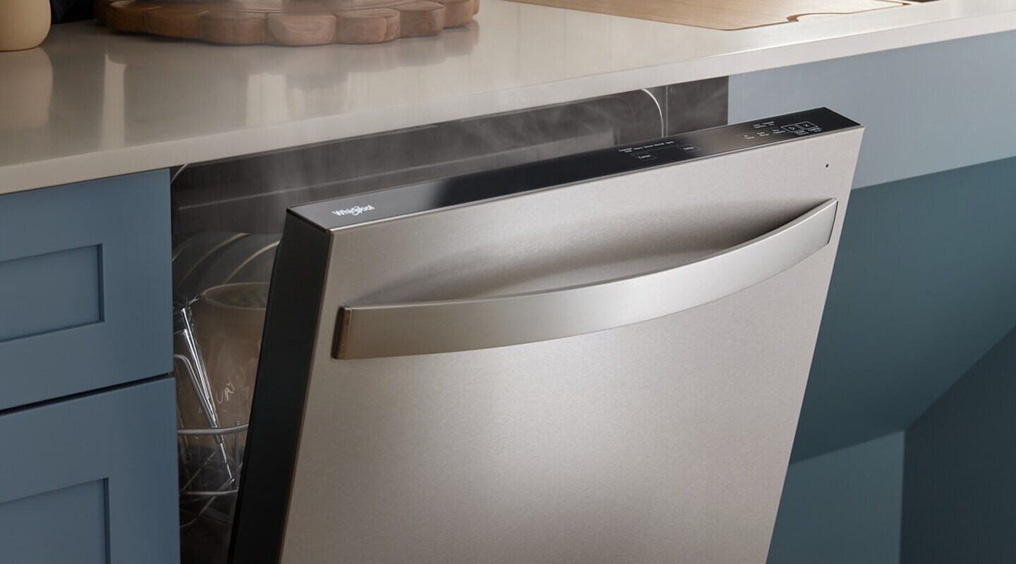 An open Whirlpool® Dishwasher with steam coming out