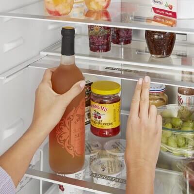 Person placing wine inside a refrigerator
