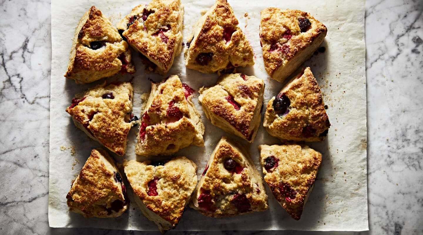 A batch of fresh scones resting on parchment paper A batch of fresh scones resting on parchment paper
