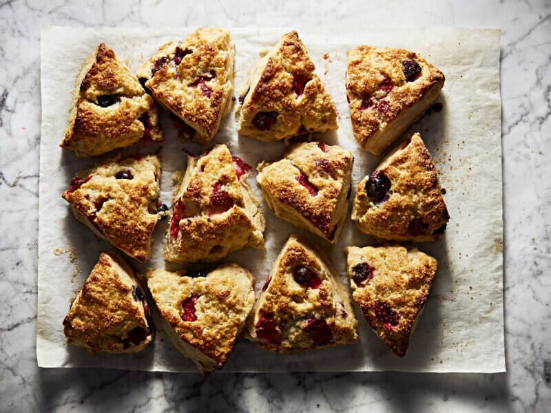 A batch of fresh scones resting on parchment paper A batch of fresh scones resting on parchment paper