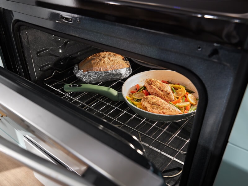 One pan meal and bread inside an oven One pan meal and bread inside an oven