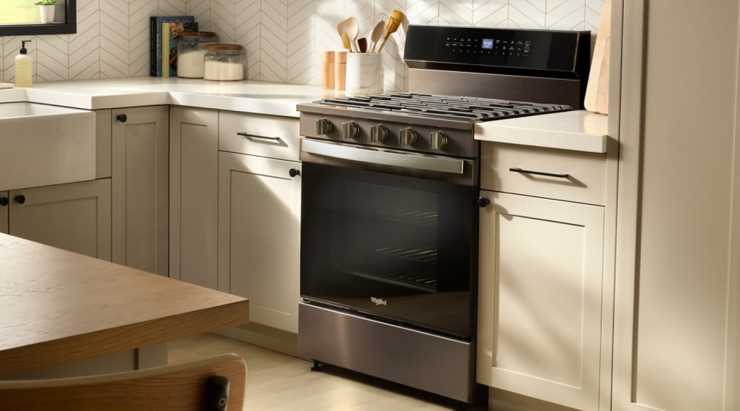 Gas range in a bright kitchen with light cabinets