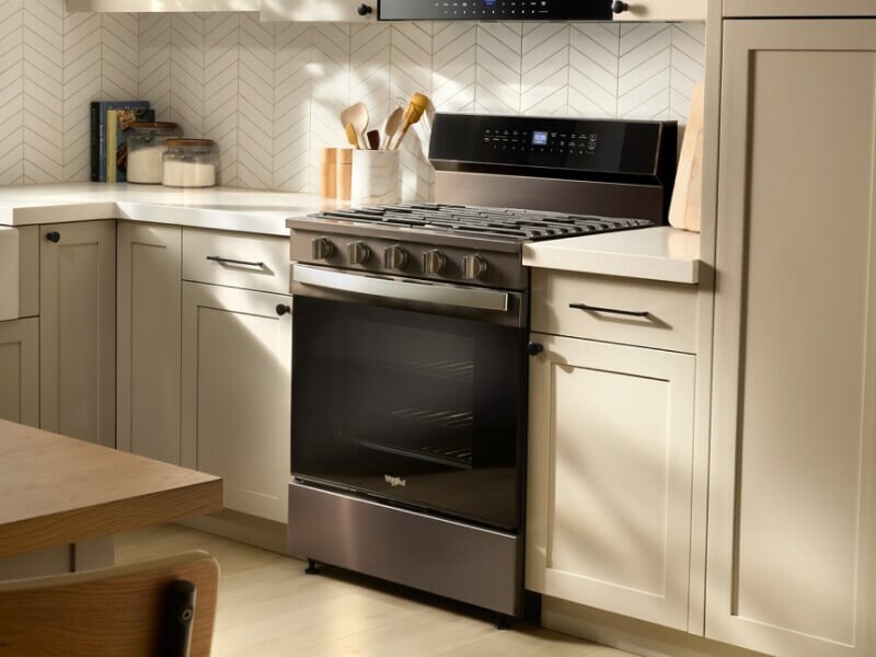 Gas range in a bright kitchen with light cabinets