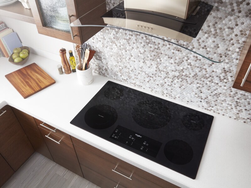 Bird’s-eye view on an induction cooktop below a range hood Bird’s-eye view on an induction cooktop below a range hood