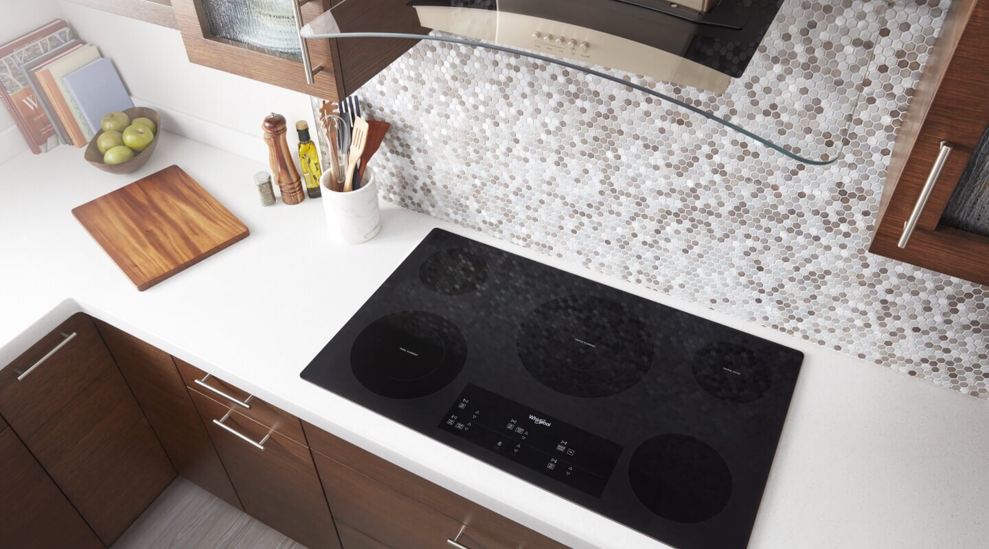 Bird’s-eye view on an induction cooktop below a range hood Bird’s-eye view on an induction cooktop below a range hood