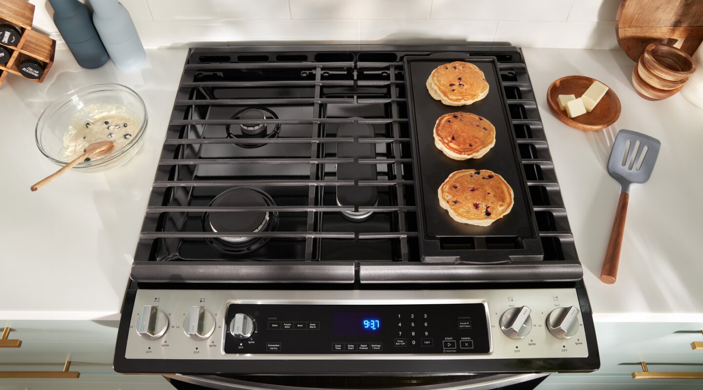 Pancakes cooking on a stovetop griddle Pancakes cooking on a stovetop griddle