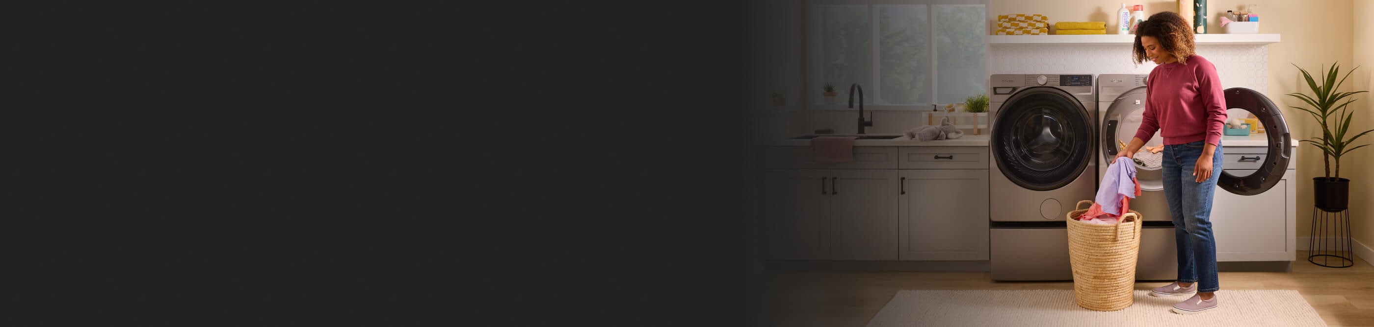 Person loading laundry into a front load washer and dryer set