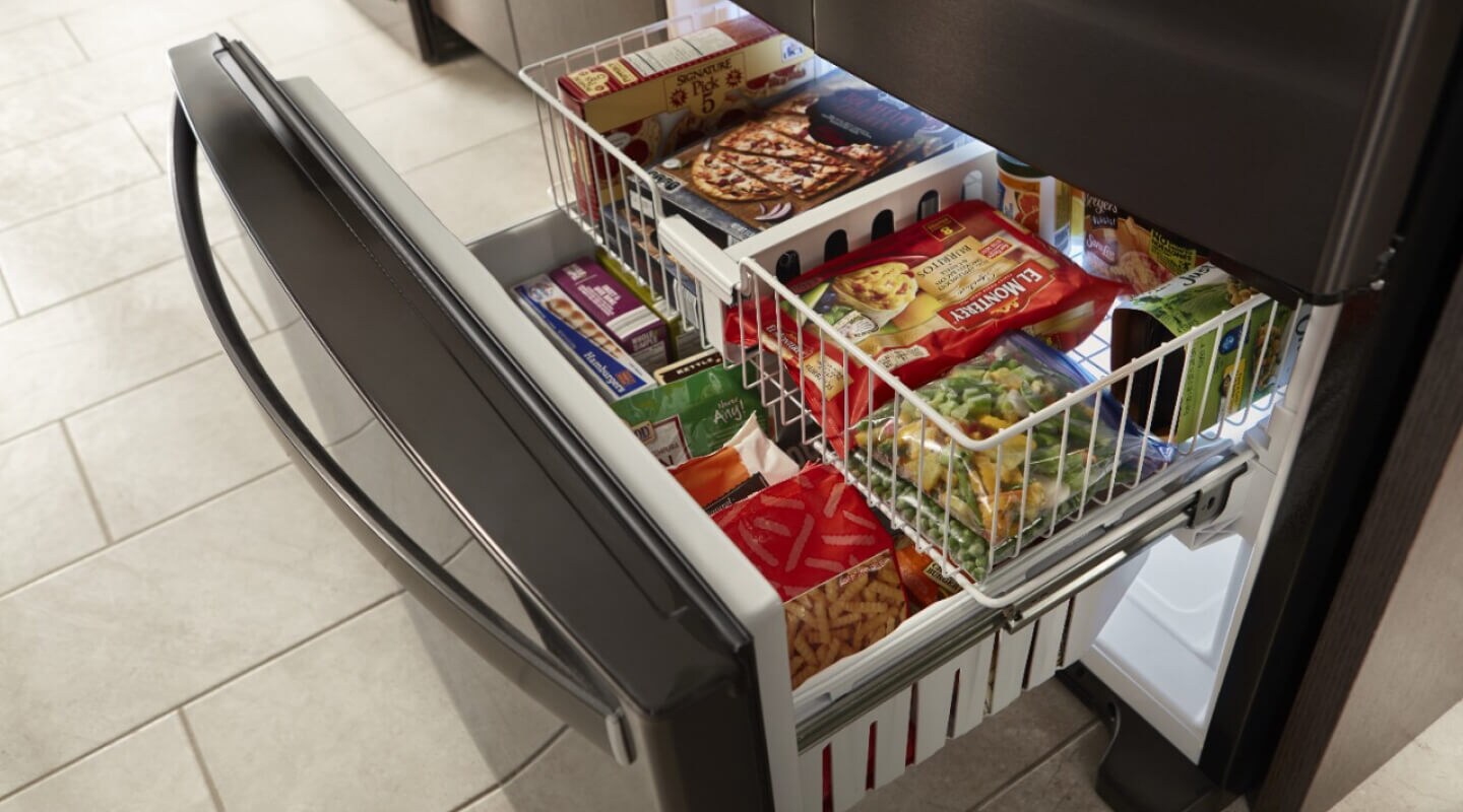 An open drawer on a bottom-freezer refrigerator