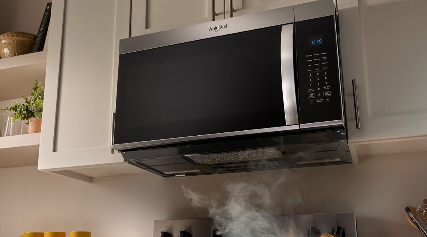 A Whirlpool® Over-the-Range Microwave with food cooking below A Whirlpool® Over-the-Range Microwave with food cooking below