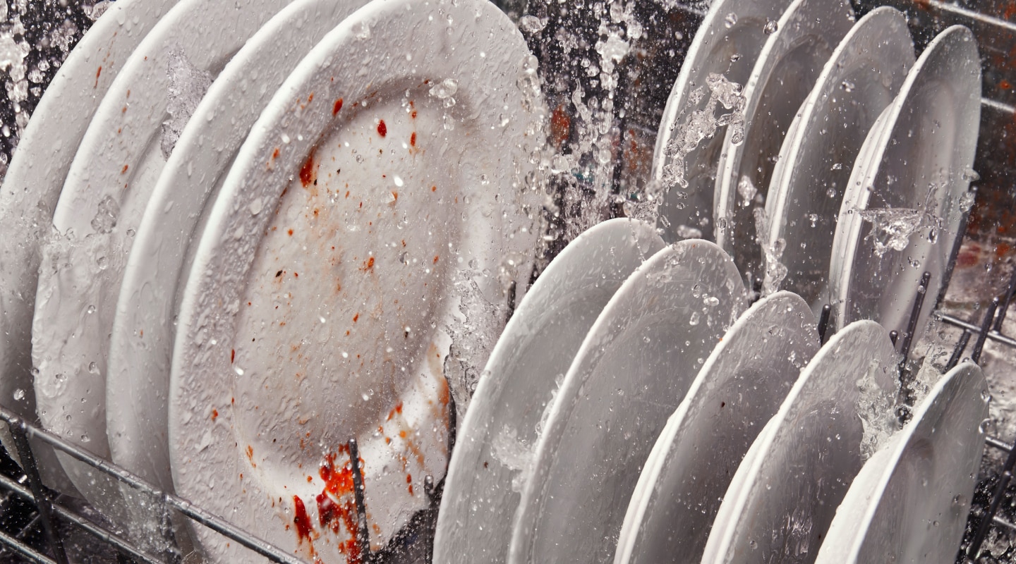 Dirty dishes inside a running dishwasher Dirty dishes inside a running dishwasher
