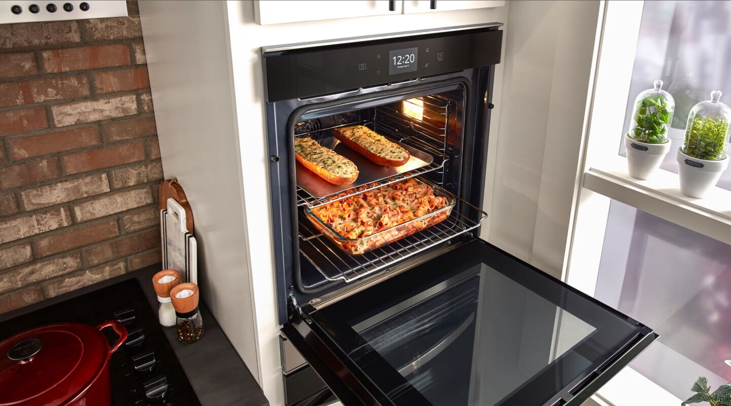 An open double wall oven with food inside