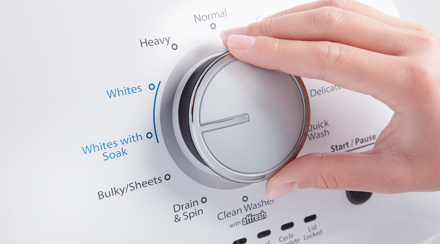 A person adjusting the settings of a washer A person adjusting the settings of a washer