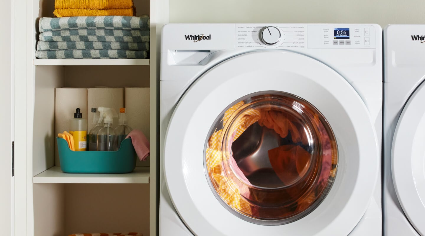 A laundry supply cabinet next to a white washer A laundry supply cabinet next to a white washer