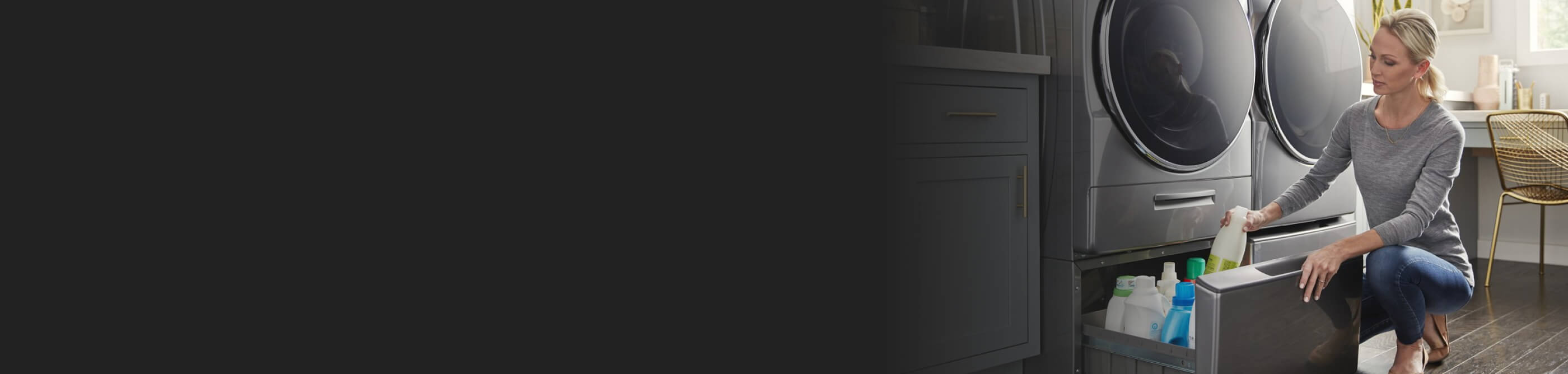 A person accessing laundry supplies in a pedestal drawer