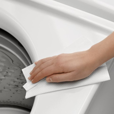 Person wiping outside of washing machine