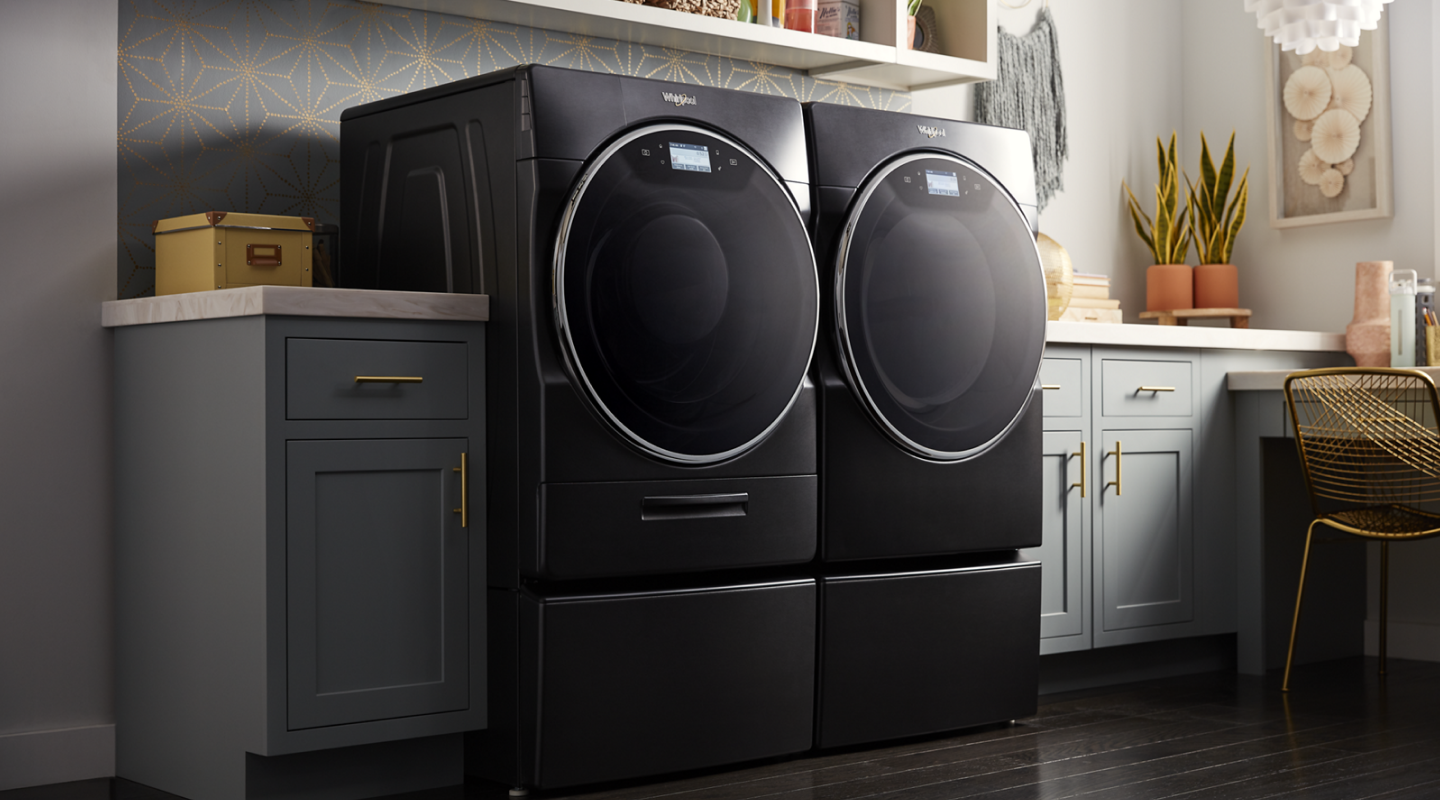 Whirlpool® Front Load Washer and Dryer in Black Shadow in a laundry room with gray cabinets Whirlpool® Front Load Washer and Dryer in Black Shadow in a laundry room with gray cabinets