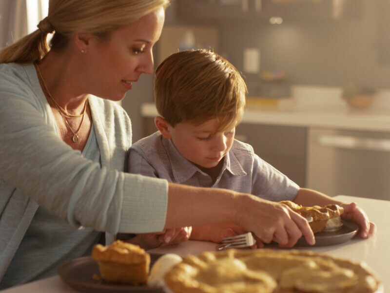 A mom serving her son a slice of pie A mom serving her son a slice of pie
