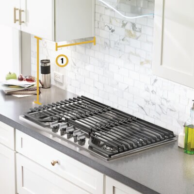Gas cooktop set into gray countertop with measurements noted from below cabinets