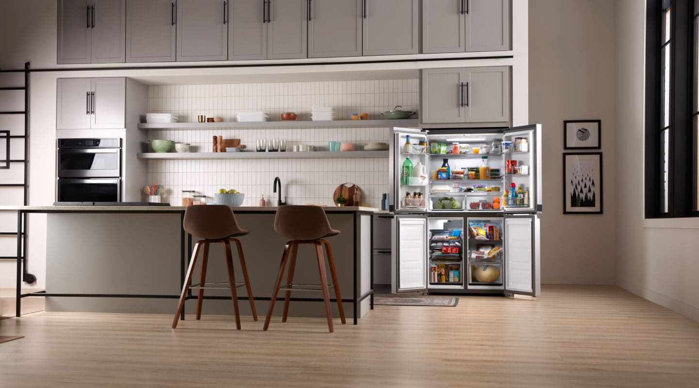The inside of a kitchen with a counter-depth refrigerator shown with its doors open