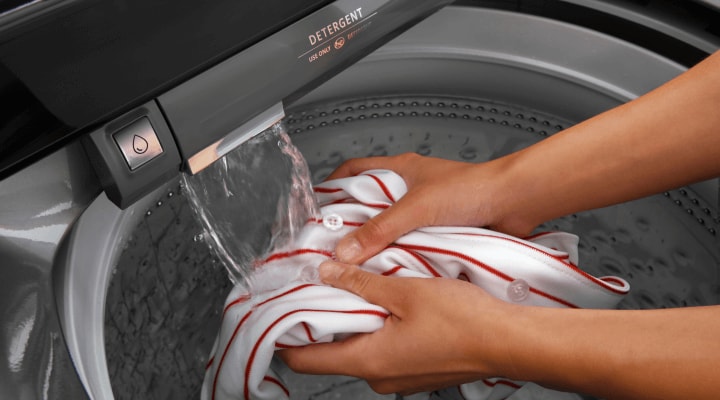 Person rinsing items in a washing machine Person rinsing items in a washing machine