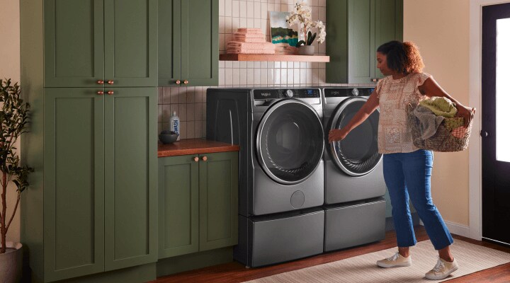 Person doing laundry in front of a washer and dryer set