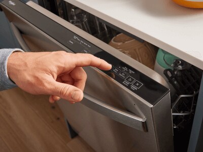 Person selecting a cycle on a top control dishwasher