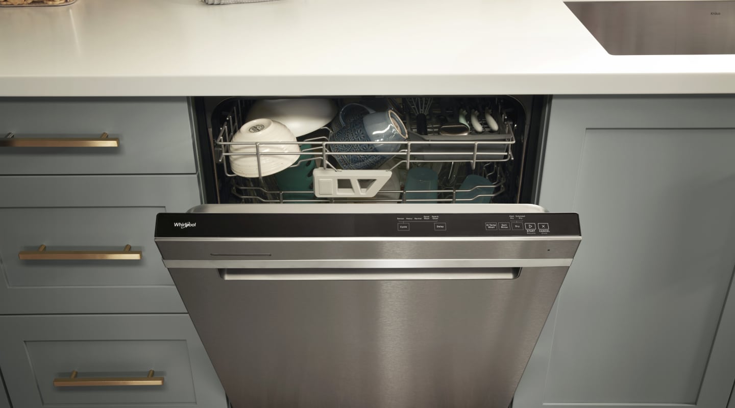 A loaded Whirlpool® dishwasher with an open door A loaded Whirlpool® dishwasher with an open door