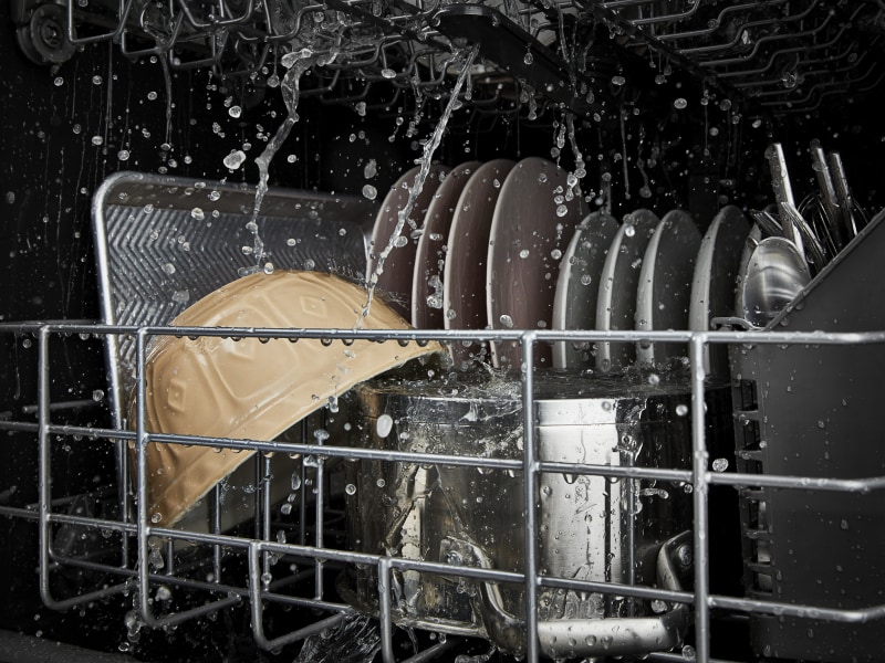 Dishes being rinsed in a dishwasher Dishes being rinsed in a dishwasher