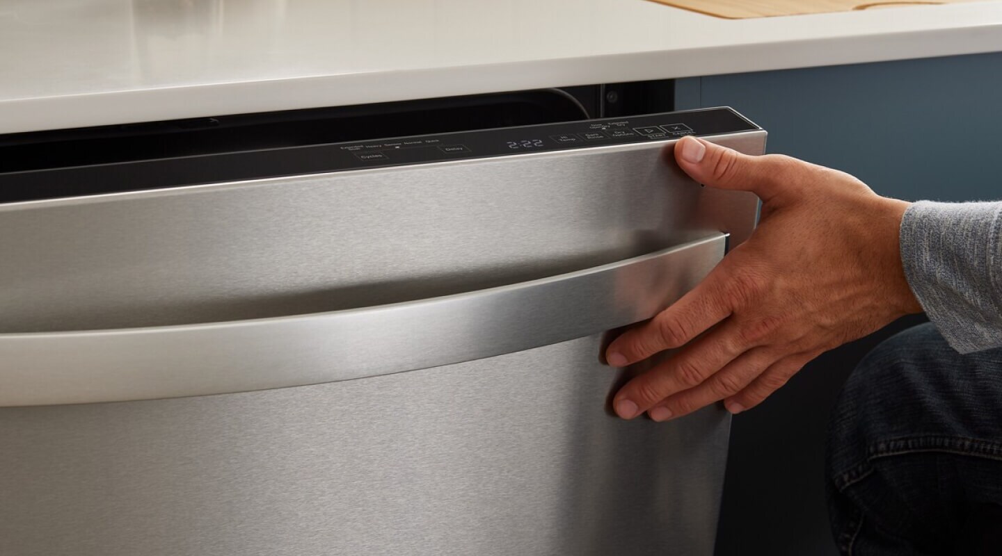 A person closing the door of a dishwasher A person closing the door of a dishwasher