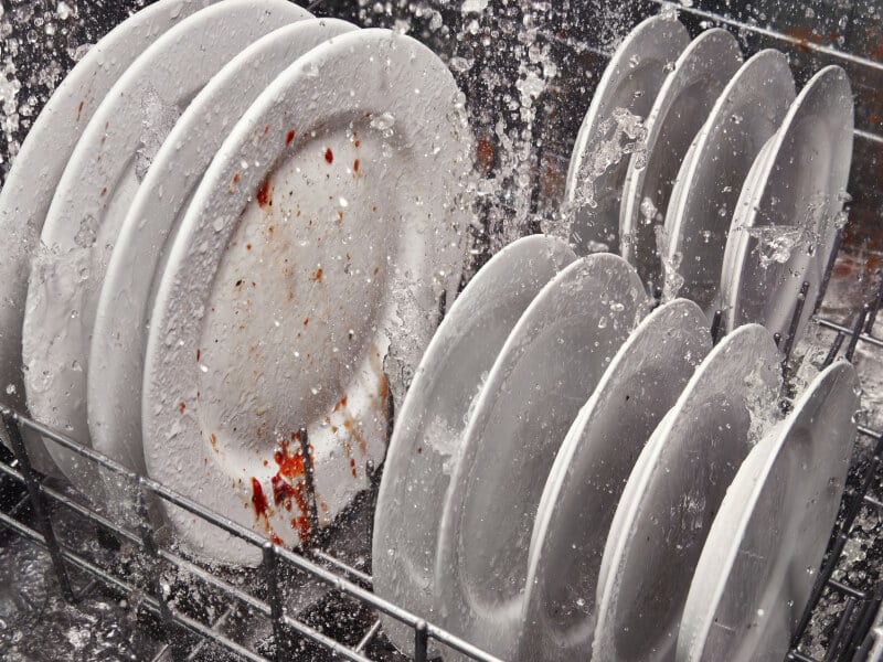 Dirty dishes being cleaned inside a dishwasher