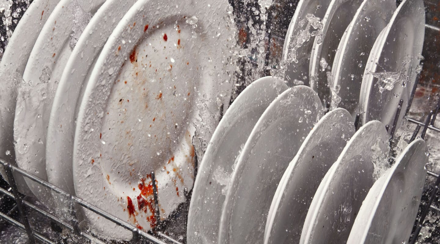 Dirty dishes being cleaned inside a dishwasher