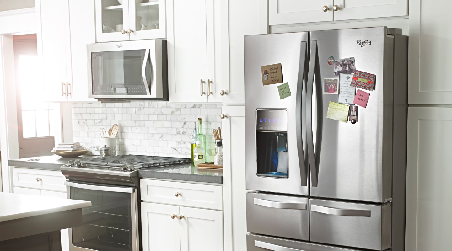 A stainless steel refrigerator with several items stuck onto it